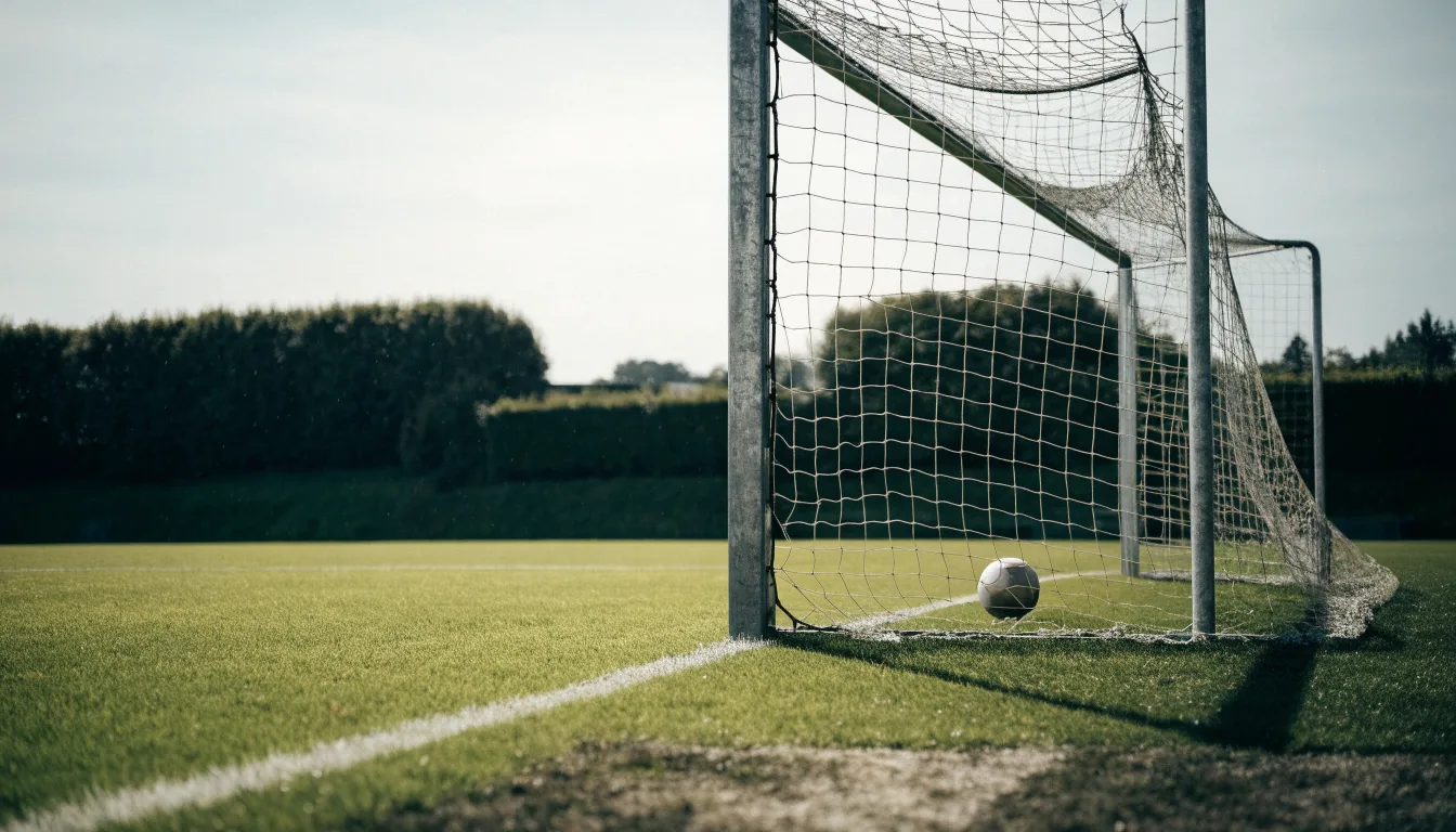 Ein Fussballtor mit locker hängendem Netz auf einem Trainingsplatz, das sich leicht im Wind bewegt.